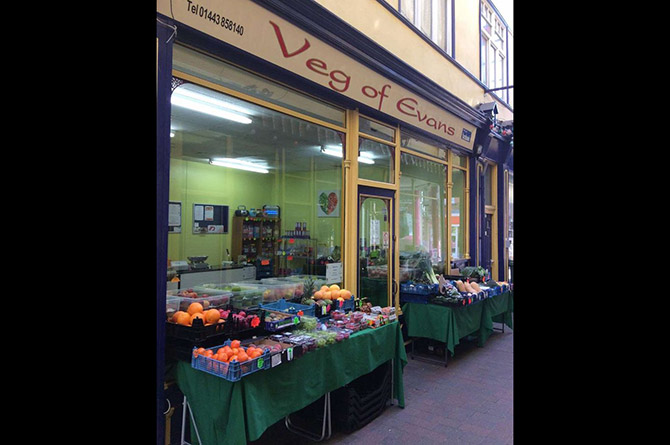 The original Veg of Evans shop in Jones Arcade, with fruit crates out front on green-clothed tables